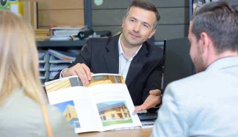 Promoteur immobilier présentant les biens immobiliers disponibles à l'achat à des futurs propriétaires