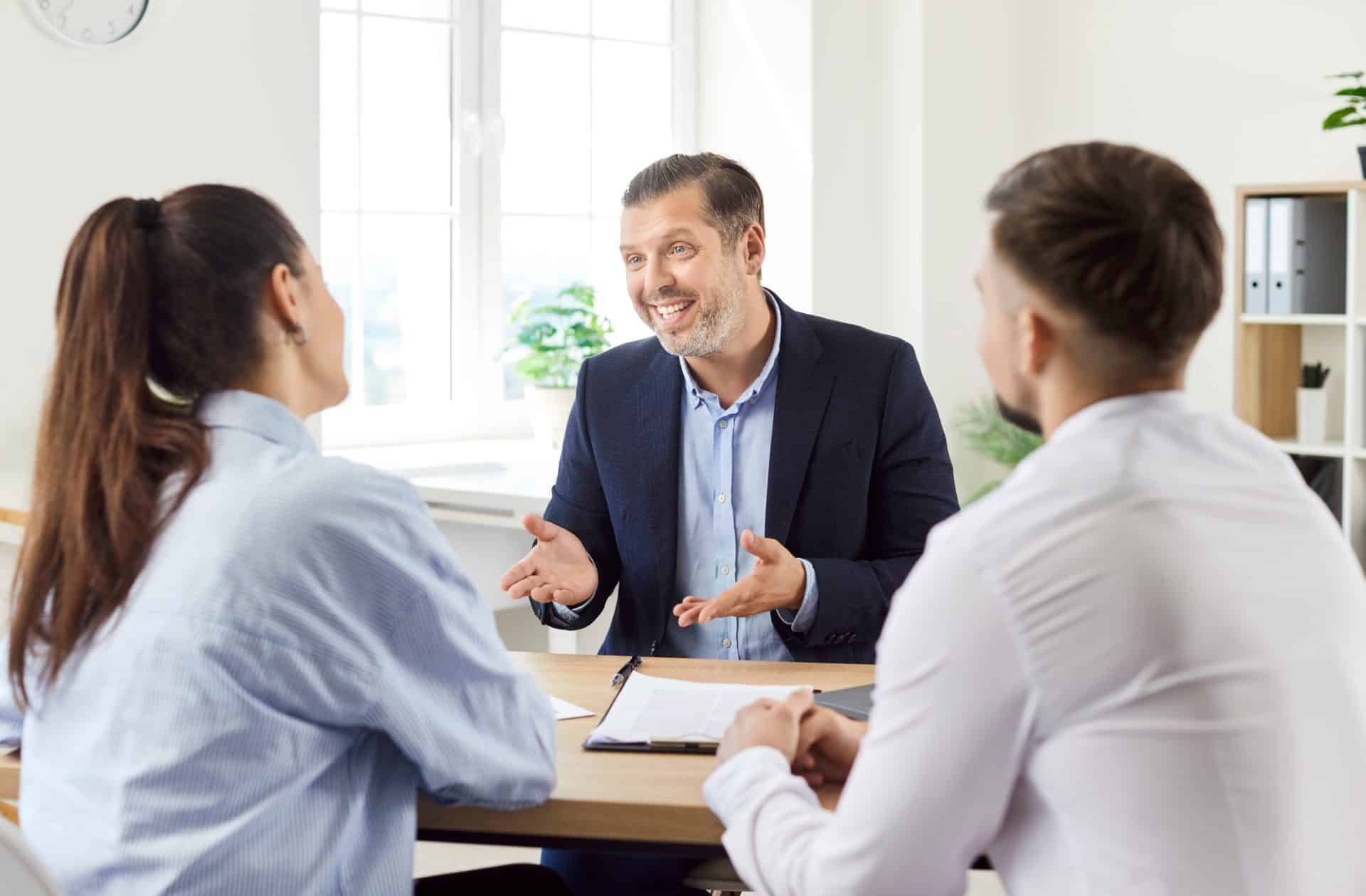 Courtier professionnel en train de conseiller un couple pour l'obtention de leur crédit immobilier